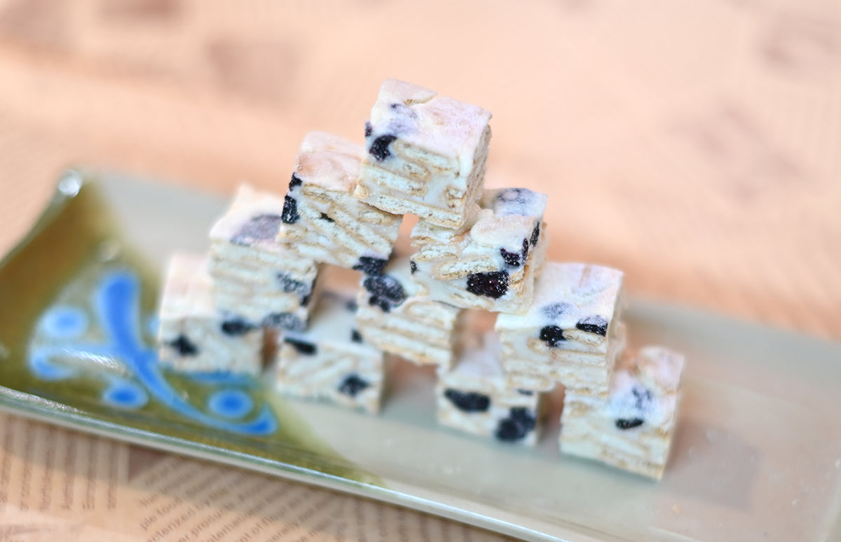Handmade snowflake crisps with dried fruit, layered cracker dessert on a green plate
